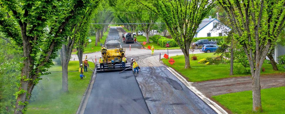 City crews paving the road in a residential neighbourhood.